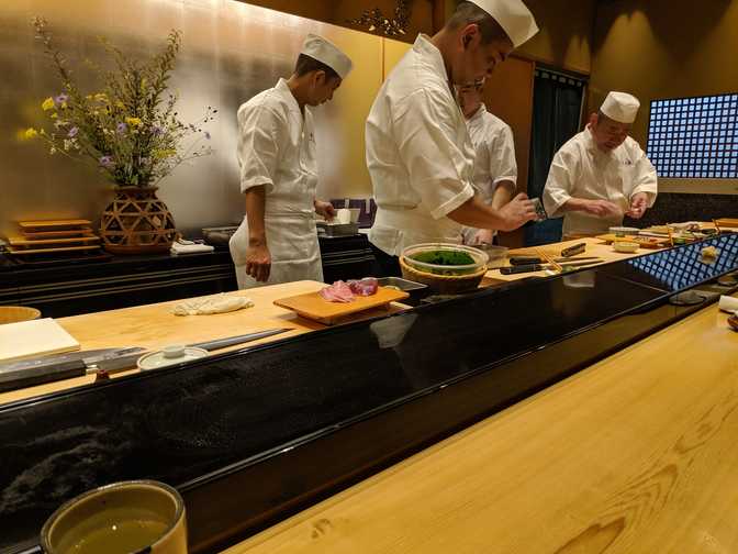 I was sat at a long counter with four chefs, here are three of them (along
with one of the many assistants who constantly come in and out to give eel,
shrimp, soup, and other things, to the chefs). Another one was on my left. It
was interesting that everyone ate off of one long shared plate.